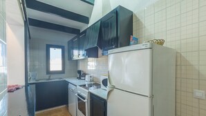 Una cocina con refrigerador, horno y lavamanos.