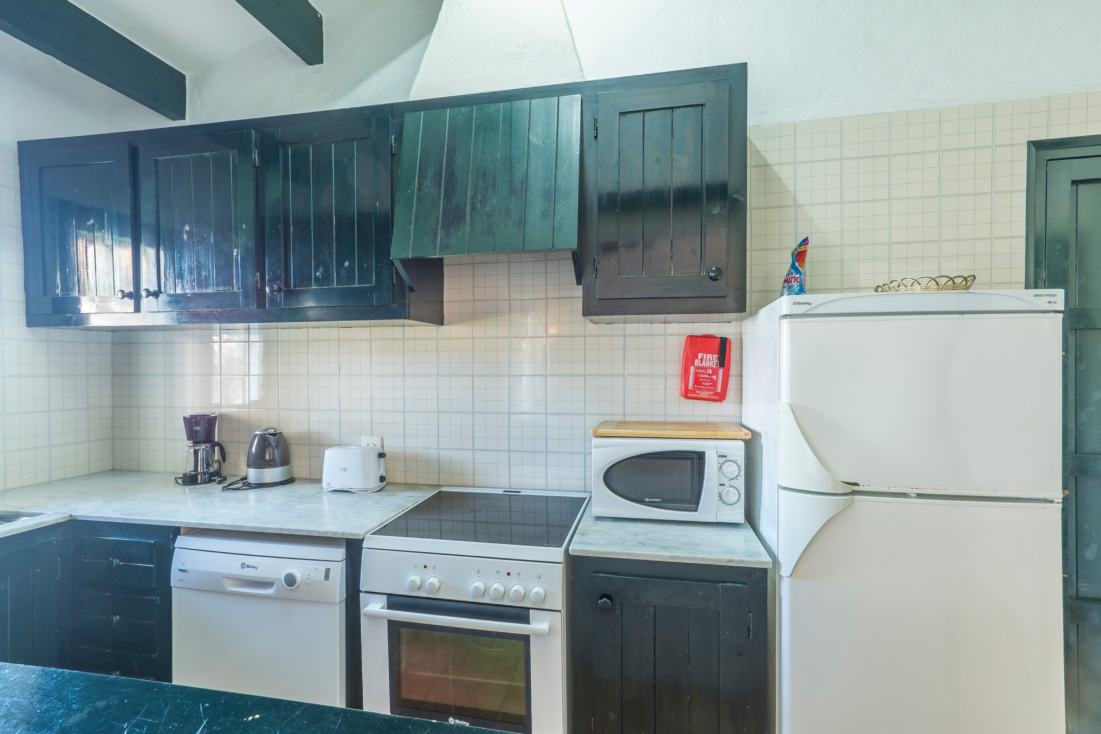 A kitchen with a dishwasher, stove, oven, microwave, and refrigerator.
