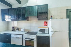 A kitchen with a dishwasher, stove, oven, microwave, and refrigerator.