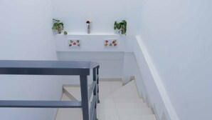 A staircase with a metal railing leading to a landing. - Syariah Amethyst Cengkareng (Jakarta)