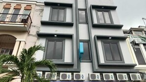 A multi-story building with a symmetrical facade, featuring large windows and air conditioning units. - Syariah Amethyst Cengkareng (Jakarta)