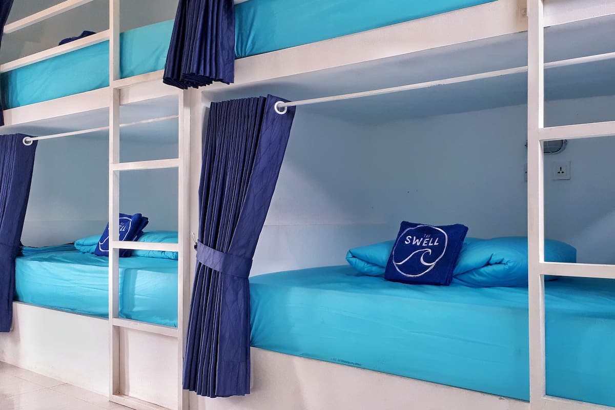 A bunk bed room with blue bedding and curtains.