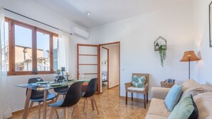 Un soggiorno moderno con zona pranzo, divano e vista esterna.