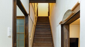 Un escalier en bois, doté d’une rampe, menant à un palier.