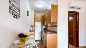 Una cocina con armarios de madera, un refrigerador, lavadora y microondas.