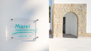 A sign for 'Marei Apartamentos' with a stone archway in the background.