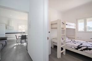 Ein Schlafzimmer mit Etagenbetten, einem Schreibtisch und einem Stuhl.