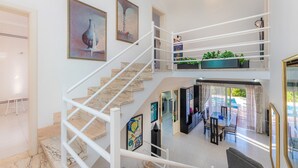A multi-level interior with a staircase, dining area, and outdoor view. - Villa With Pool in Idyllic Location - Ca Na Xisca (Sa Coma)