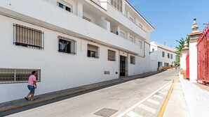 A white building with barred windows and a gated entrance.