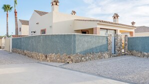 A modern house with a stone wall, a tiled roof, and a stone entrance. - Air-Conditioned Apartment Close to the Beach with Pool, Terrace, Garden & Wi-Fi (Zahora)