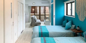 A hotel room with two beds, a small table, a chair, a window with blinds, and a view of the outside. - WARAYUN SO Port city May (Naha)