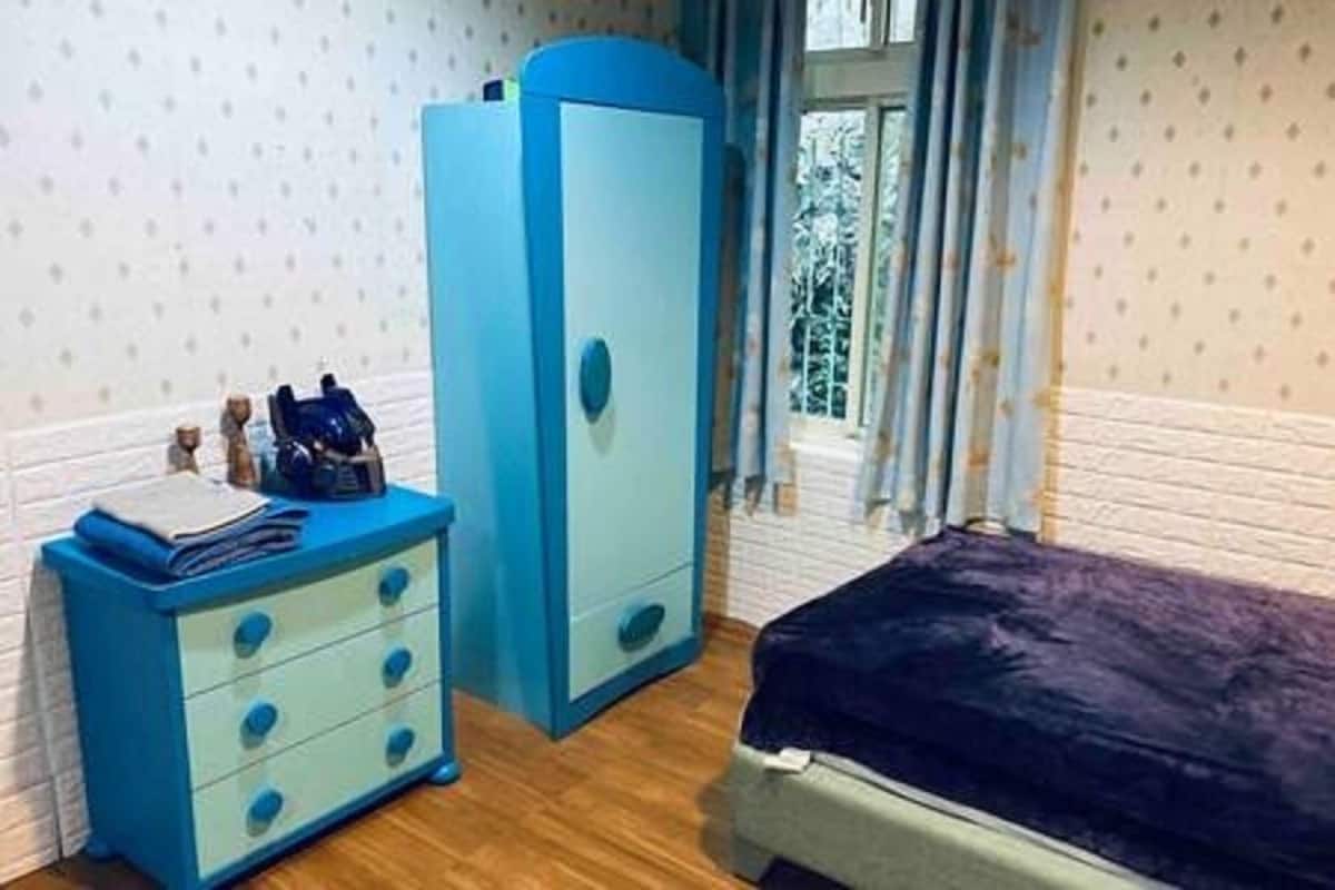 A bedroom with a bed, a dresser, and a wardrobe.