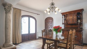 A dining room with a wooden table, chairs, a chandelier, and a cabinet. - Beautiful Holiday Home with Mountain View, Pool, Wi-Fi, Garden and Air Conditioning (Santa Eulalia del Río)