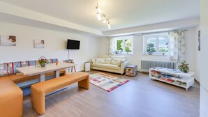 Una sala de estar moderna con un sofá, un banco, una mesa y una estantería.
