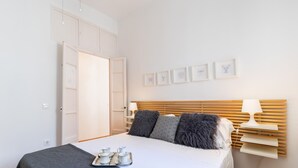 Una camera da letto con un letto, comodini, un armadio e decorazioni alle pareti.
