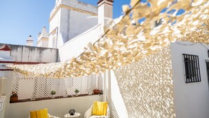 Un edificio bianco con un balcone, una recinzione bianca e un cielo azzurro limpido.