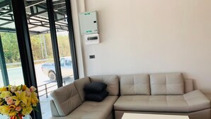 Een moderne woonkamer met een beige modulaire bank, een witte salontafel en een vaas met bloemen.