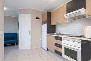 Une cuisine compacte équipée d’un réfrigérateur, d’un four et d’un four à micro-ondes.