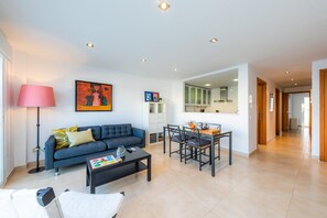 A modern living room with a sofa, coffee table, and dining area.