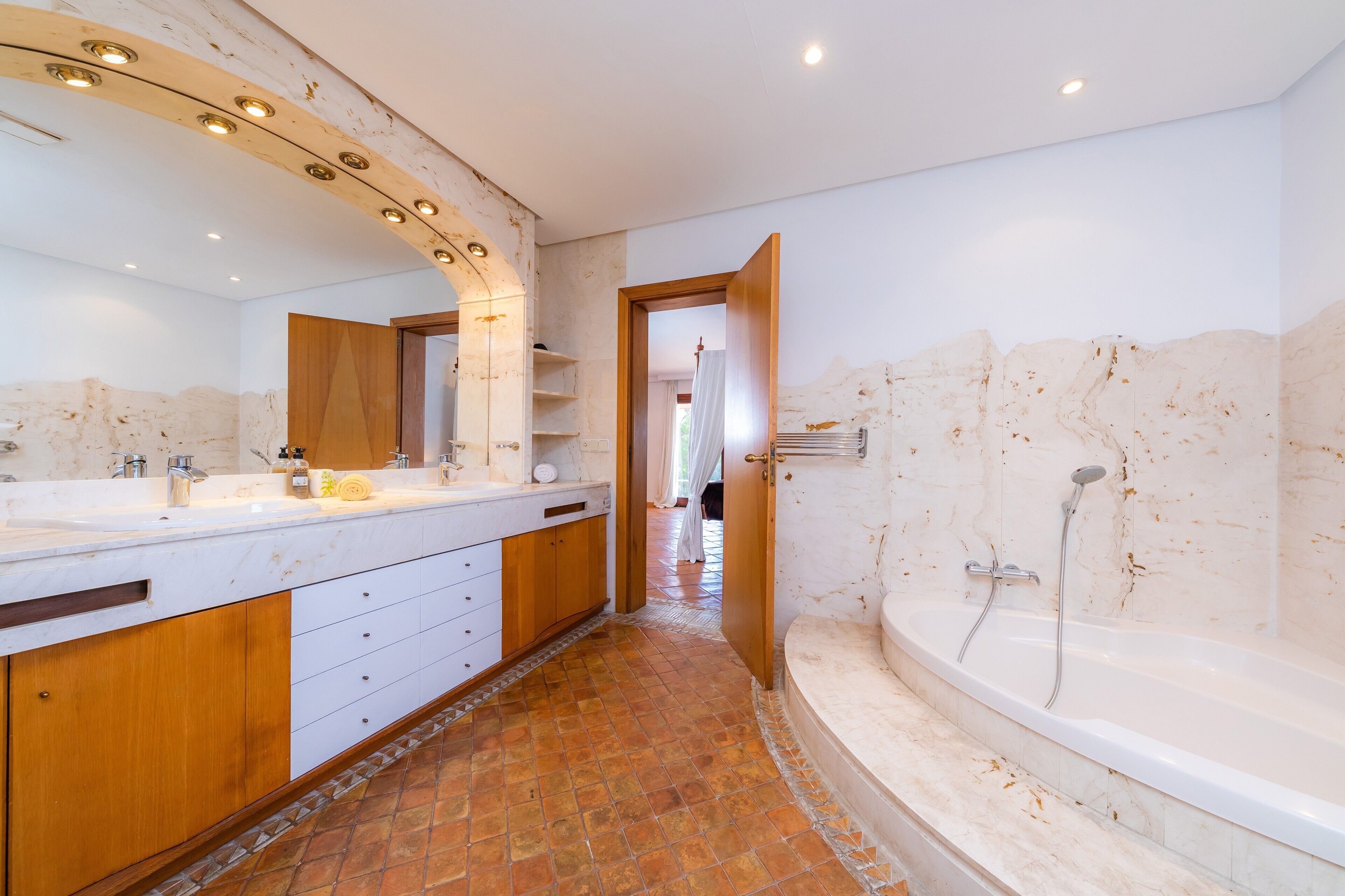 A modern bathroom with a large vanity, a bathtub, and a shower.