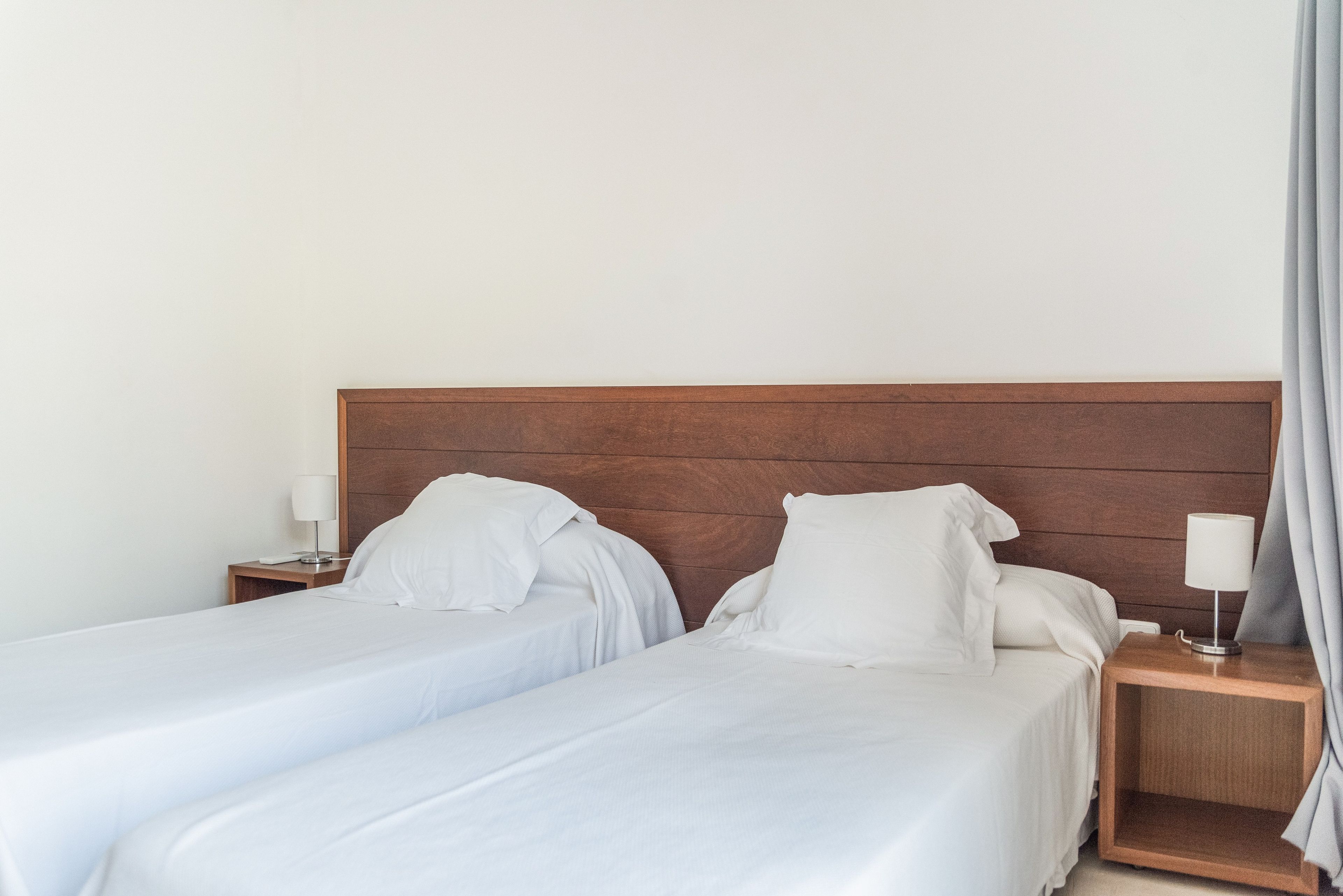 Cama doble con cabecera de madera en una habitación de hotel.
