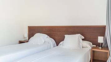 Cama doble con cabecera de madera en una habitación de hotel.