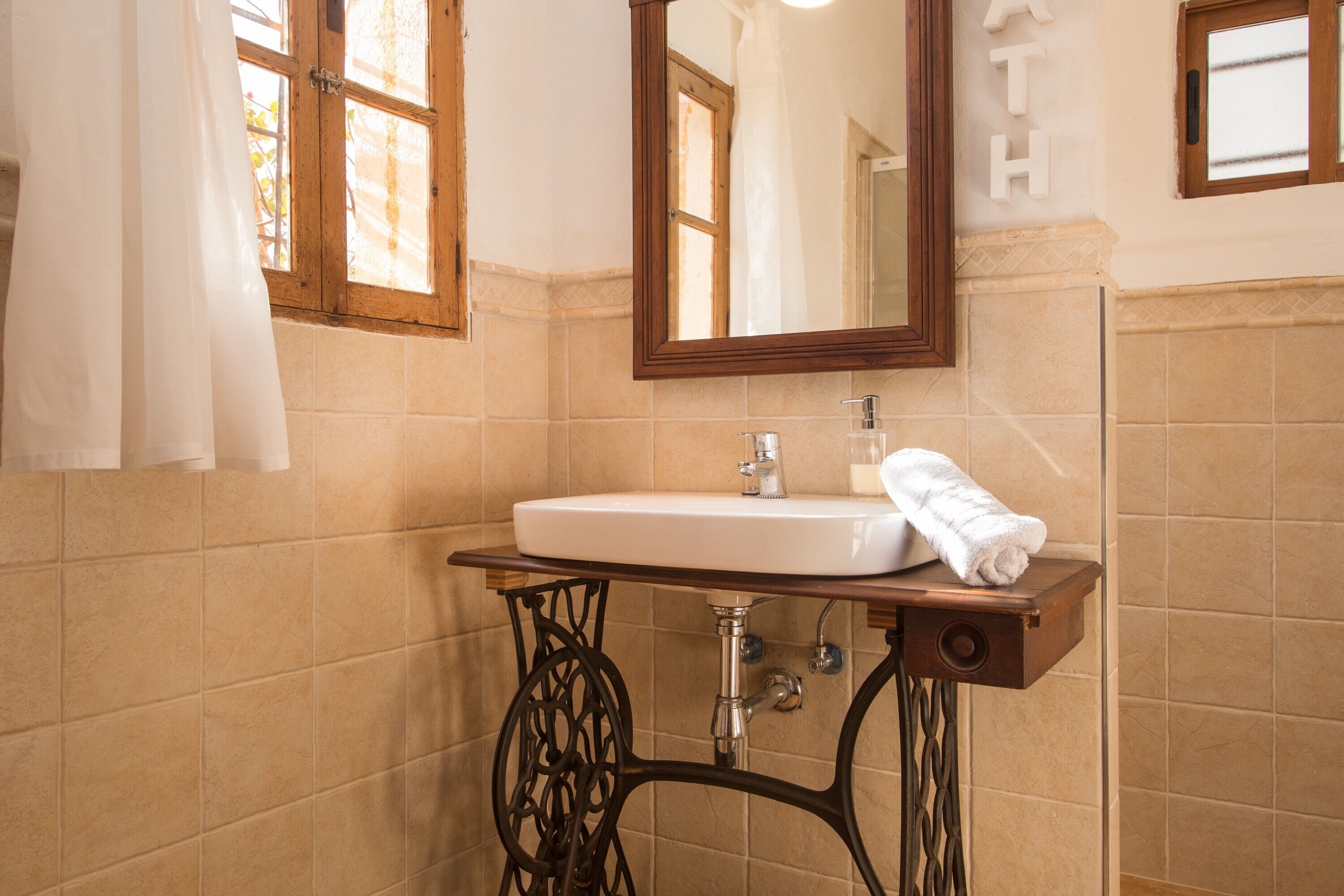 A bathroom with a sink, mirror, and towel rack.