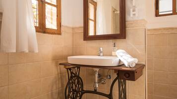A bathroom with a sink, mirror, and towel rack.