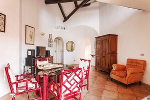 A dining area with a table, chairs, a cabinet, and a television.