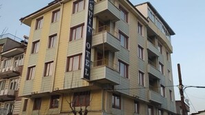 Un edificio de varios pisos con un letrero que dice "SUIT HOTEL" en la fachada.