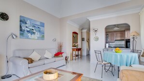Een woonkamer met een bank, salontafel en een eethoek met een tafel en stoelen.