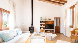A living room with a sofa, coffee table, and a fireplace. - Villa Marilen near Can Picafort Beach with Mountain Views, Wi-Fi and A/C (SANTA MARGALIDA)