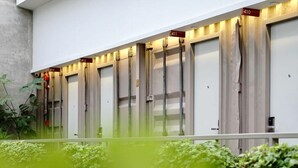 A row of hotel rooms with numbers 411 to 412, each with a door and a small window. - Kollektiv Hotel (Bandung)