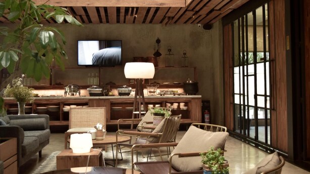A modern living room with a sofa, chairs, a coffee table, and a TV. - Kollektiv Hotel (Bandung)
