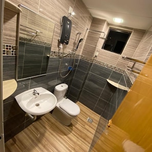 A modern bathroom with a sink, toilet, and shower area.