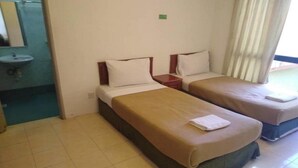 A hotel room with two single beds, a small bedside table, a nightstand, a bathroom with a sink, and a window with curtains. - Marina Cove Resort (Lumut)