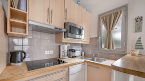 Een moderne keuken met een ingebouwde magnetron, koffiezetapparaat en vaatwasser.