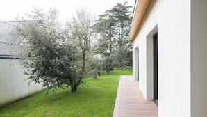 A modern building with a wooden deck and a grassy yard. - New home for 4 adults - 2 children - Garden (Piriac-sur-Mer)