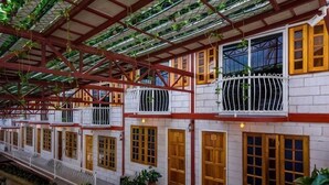 A covered building with multiple balconies, wooden doors, and potted plants. - Kea Garden Mini Chalet (Brinchang)