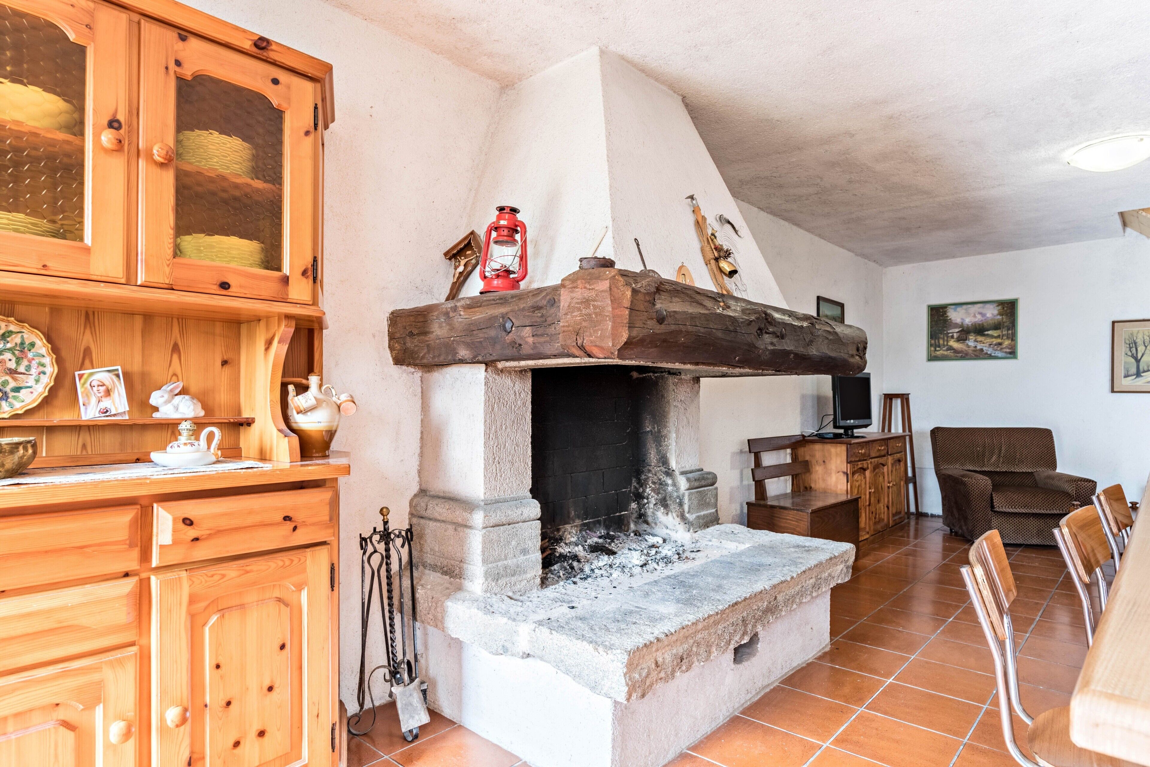 Un intérieur rustique avec une cheminée en pierre, des meubles en bois et un coin repas.