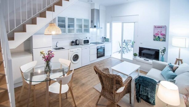 A modern apartment with a kitchen, dining area, and living room. - Duplex Flamingo Cadiz (Cádiz)