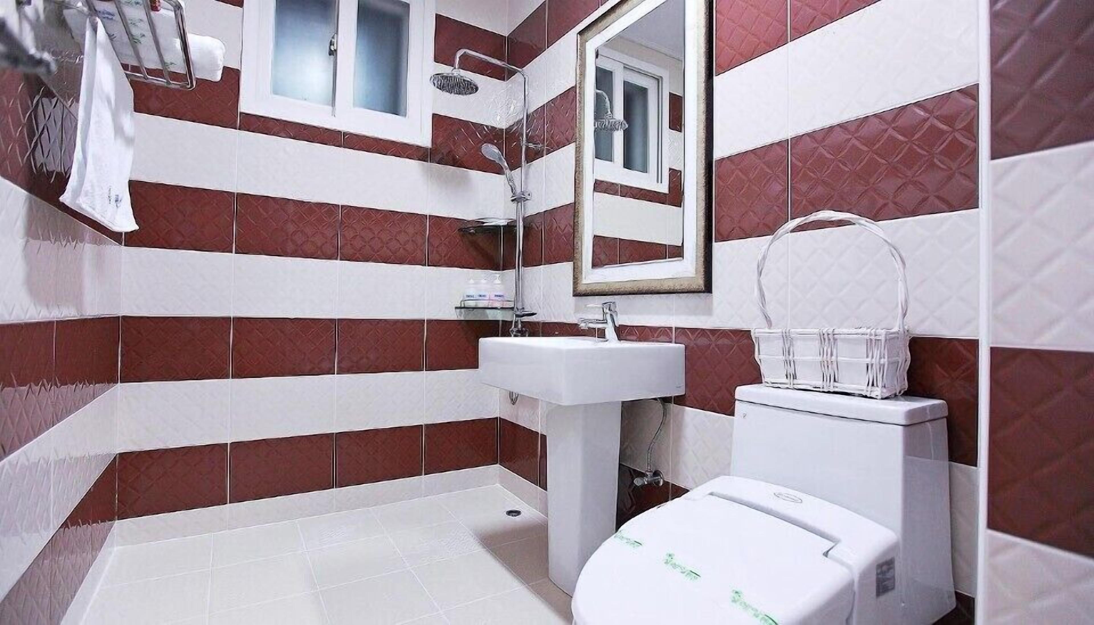 A bathroom with a white sink, a mirror, and a toilet.