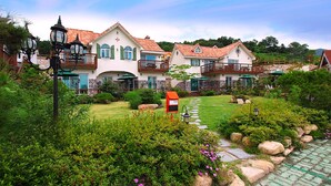 A large, two-story house with a garden pathway leading to the entrance.