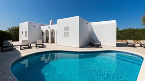 A modern pool area with a clear blue pool, white walls, and lounge chairs. - Holiday Home "Ca Sa Mola" with Terrace and Pool (Cala Blanca - Ciutadella de Menorca)