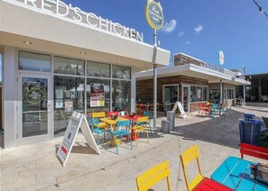 Ein Restaurant namens 'RED'S CHICKEN' mit Außenbereich und einem Schild.