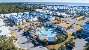 A coastal residential area with multiple houses, a central swimming pool, and a parking lot.
