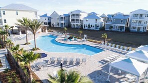 Ein Resort mit Pool, Liegestühlen und Blick aufs Meer.