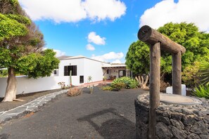 A white building with a stone pathway leading to a wooden structure.