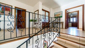 A staircase with ornate metal railings, a potted plant, and a framed picture on the wall. - Rural Villa with pool and spectacular views – Villa Sastre (Campanet)