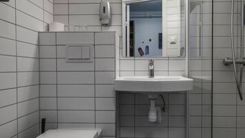 Un baño moderno con inodoro, lavamanos y ducha.